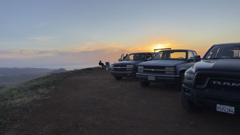 three trucks lined up at sunset