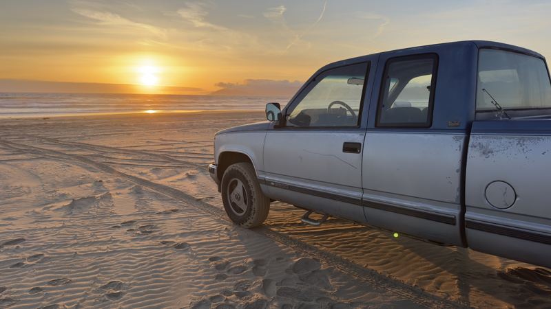 truck on the beach at sunset